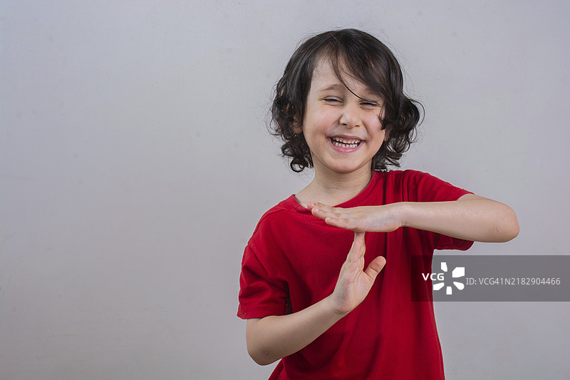 微笑的小男孩做出暂停或休息的手势图片素材