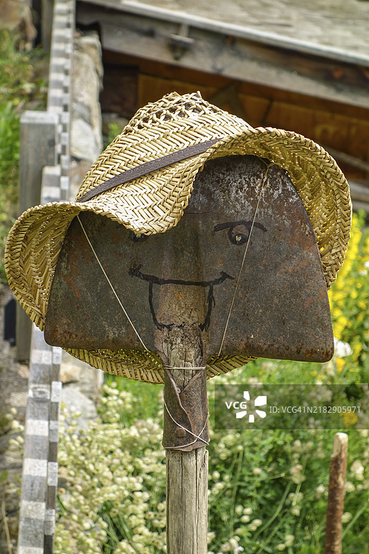 带有彩绘面孔和稻草帽的铲子作为装饰性花园元素，阿尔卑斯山，奥地利，欧洲图片素材
