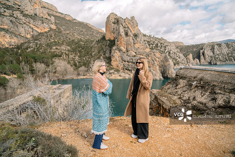 女性朋友们在山上站立，背对天空。图片素材