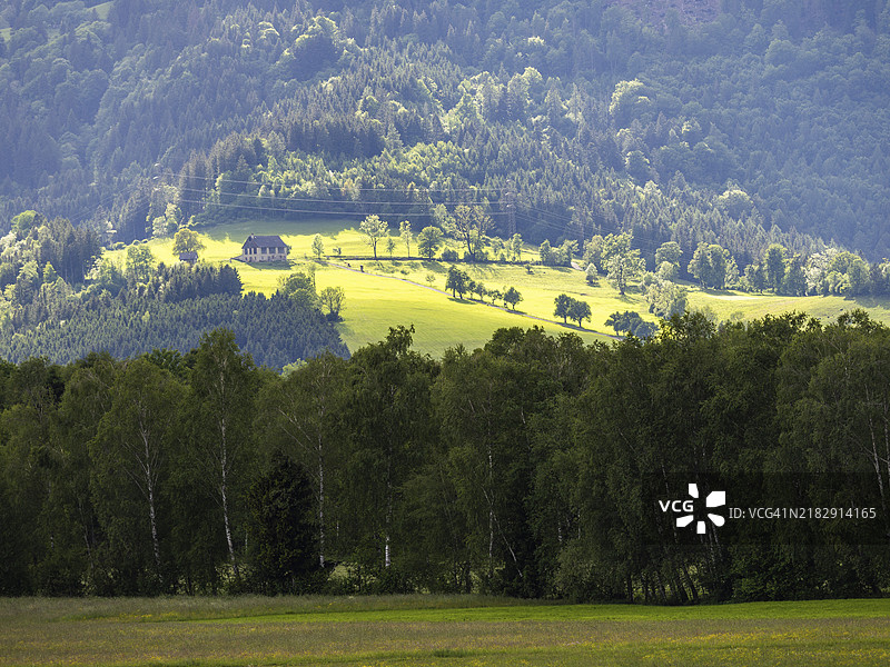 黄昏的光线洒在奥地利斯蒂里亚州伊尔德宁附近森林边缘的一座农舍上图片素材