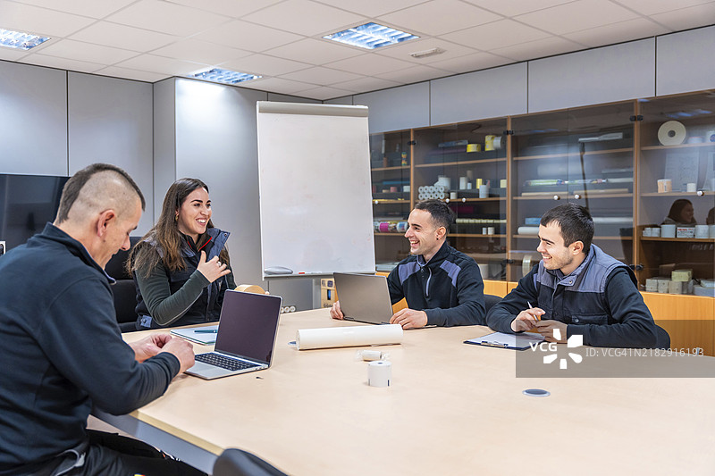 一群工程师在会议室里坐在沙发上讨论会议。图片素材