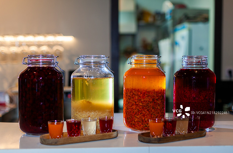 调酒师在玻璃罐中准备自制的浆果利口酒和药酒图片素材