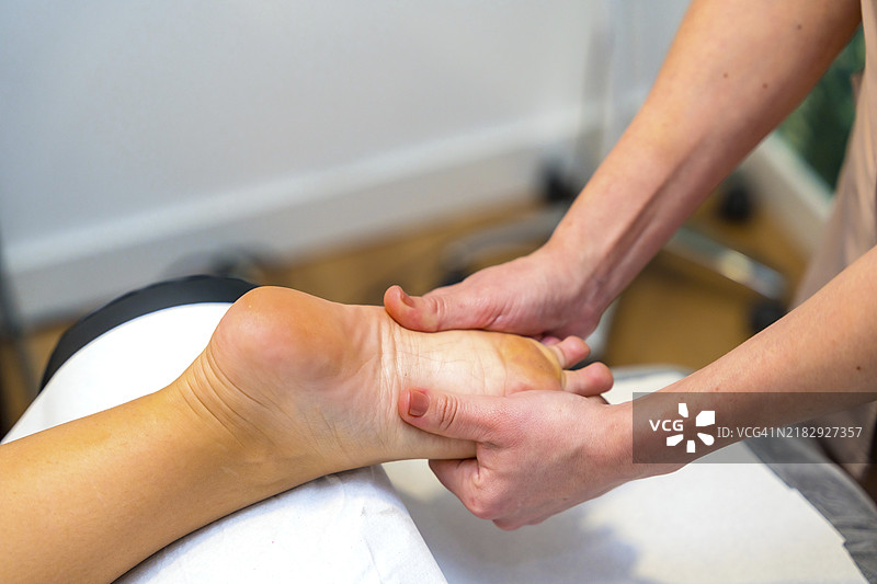 一位无法辨认的女性在诊所接受足部按摩的特写镜头图片素材