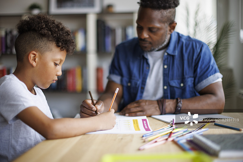 父亲在帮助儿子做作业图片素材