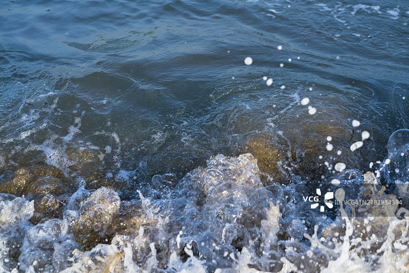 阳光明媚的日子，扎马伊亚海滩上海浪拍打的高角度视图，没有人。图片素材