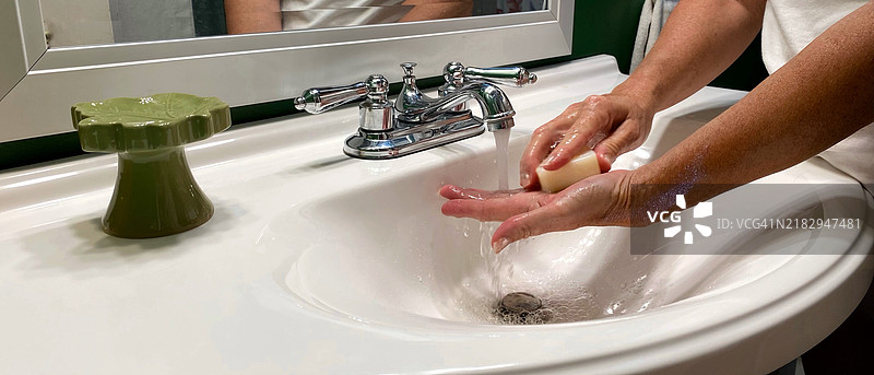 修剪后的图像，展示一位女性在水槽中洗手，宾夕法尼亚州，美国图片素材