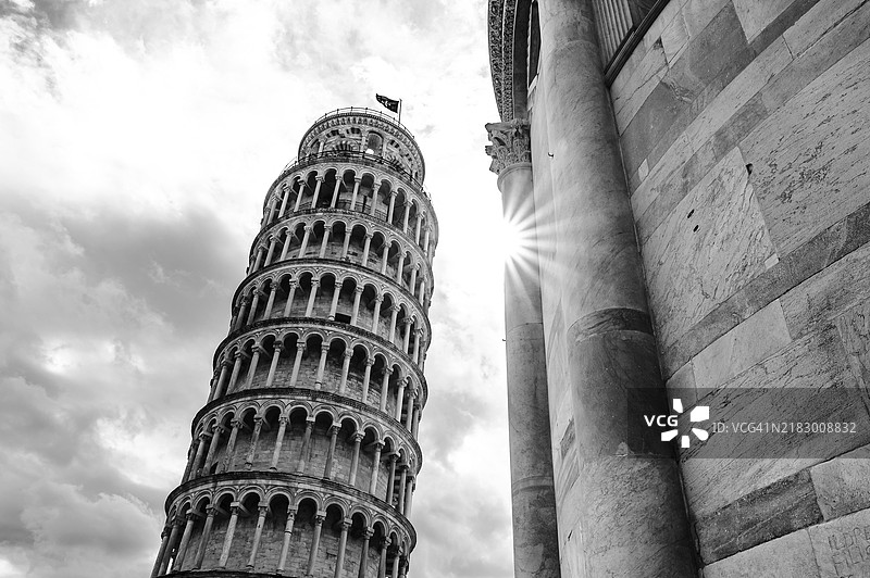 比萨斜塔在黑白色调中，背景是戏剧性的天空和阳光，意大利比萨，欧洲图片素材