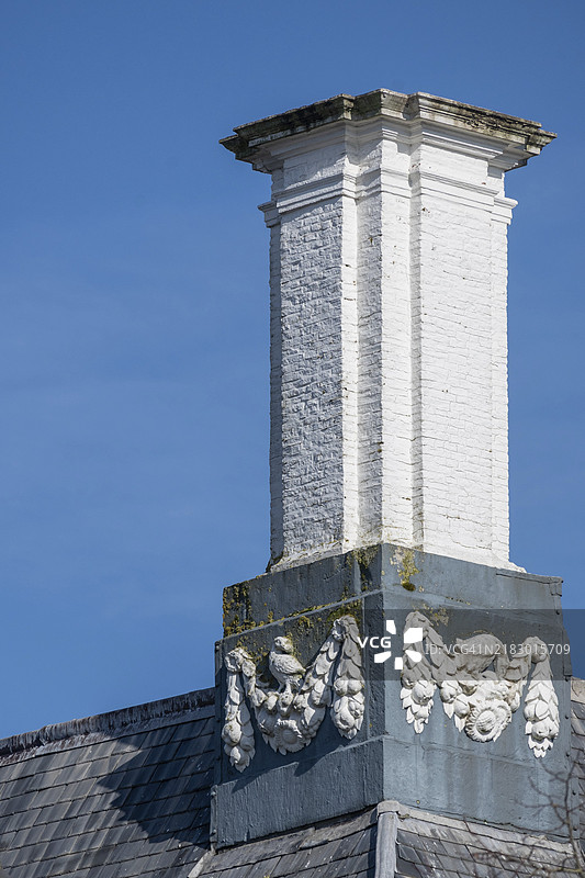 米德尔堡，泽兰，荷兰一座灰色屋顶上装饰性元素的白色烟囱特写图片素材