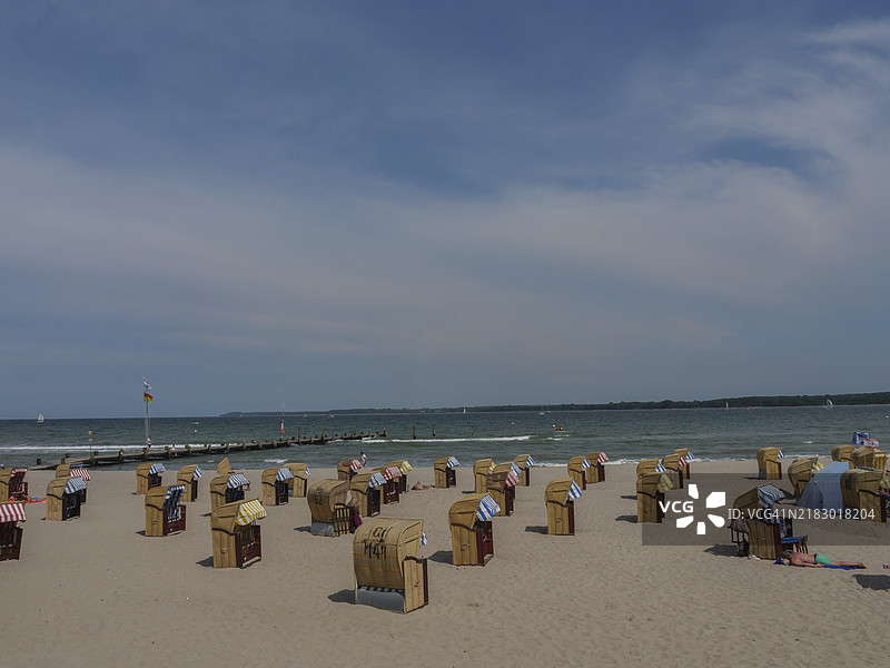 一个安静、几乎空旷的海滩，背景是海洋和清澈的蓝天，夏日宁静的日子里有沙滩椅，地点：戈斯蒙德，特拉弗门德，吕贝克，德国。图片素材