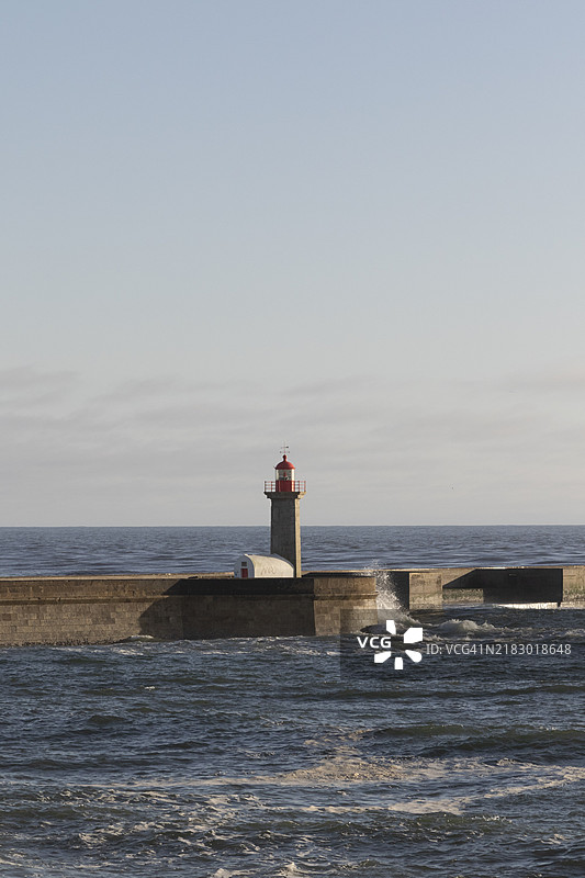 在欧洲葡萄牙波尔图区北部的福斯杜杜罗，卡尔内罗海滩的海滨长廊上，黄昏时分的费尔盖拉斯灯塔。图片素材