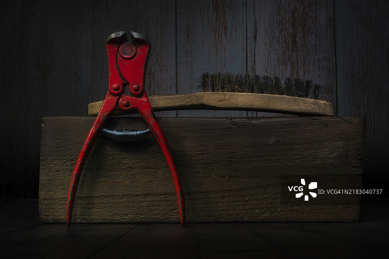 木块上的钳子和钢丝刷静物画图片素材