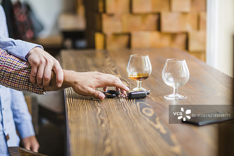 男人躲避朋友拿车钥匙的桌子图片素材