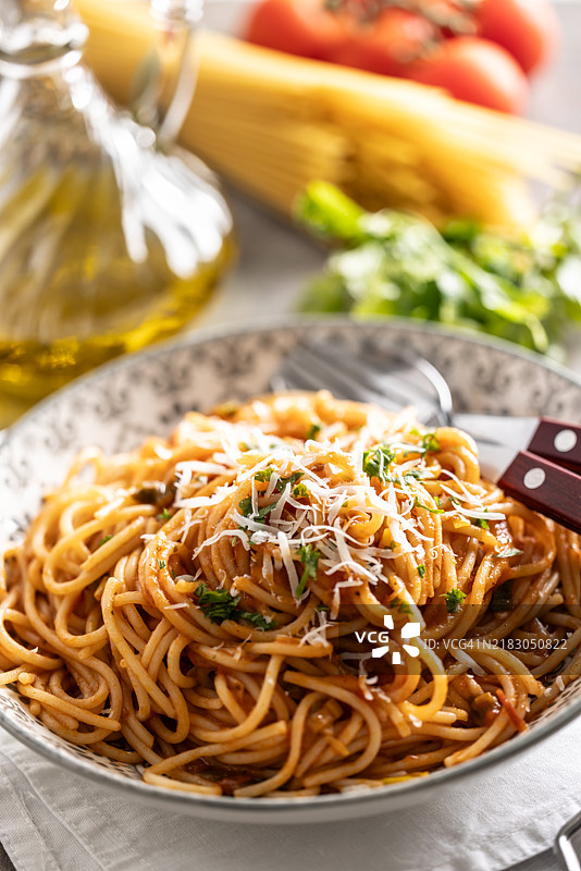 自制意大利面配番茄酱和帕尔马奶酪，摆放在盘子上。图片素材