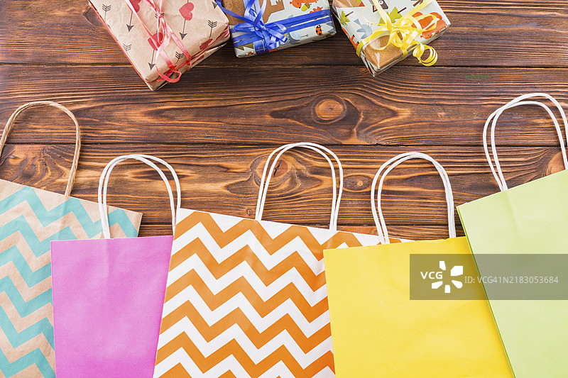 包裹礼物的装饰纸购物袋放在木质表面上图片素材