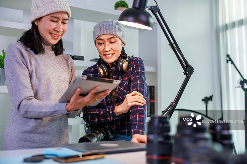 女性摄影师在专业摄影工作室合作：拍摄肖像、调整灯光，展示创意团队合作和在充满摄影设备的现代工作空间中的专业技能图片素材