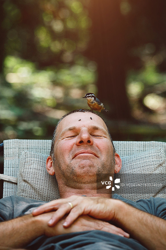 男人在给头上的鸟喂食图片素材