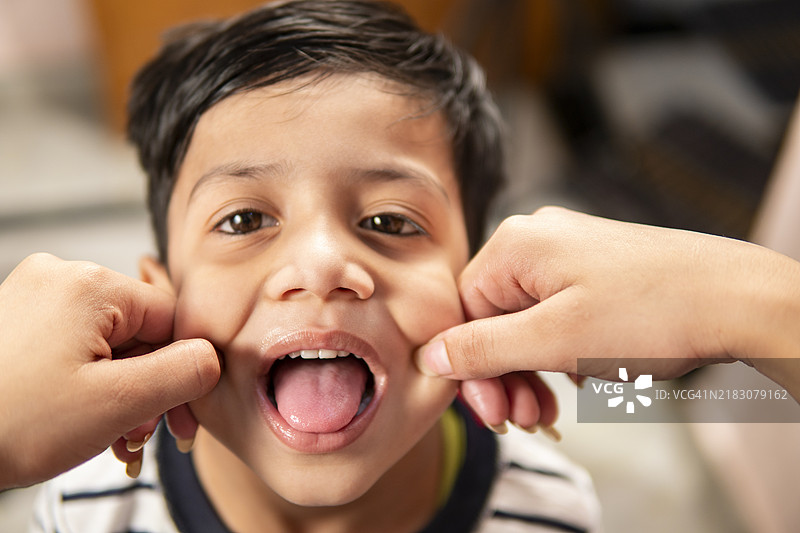 视角：手拉着小男孩的脸颊。图片素材