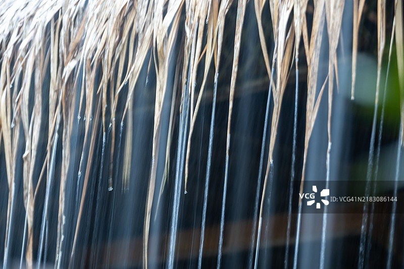 热带雨水在强烈的季风暴雨中从屋檐倾泻而下的特写镜头。泰国图片素材
