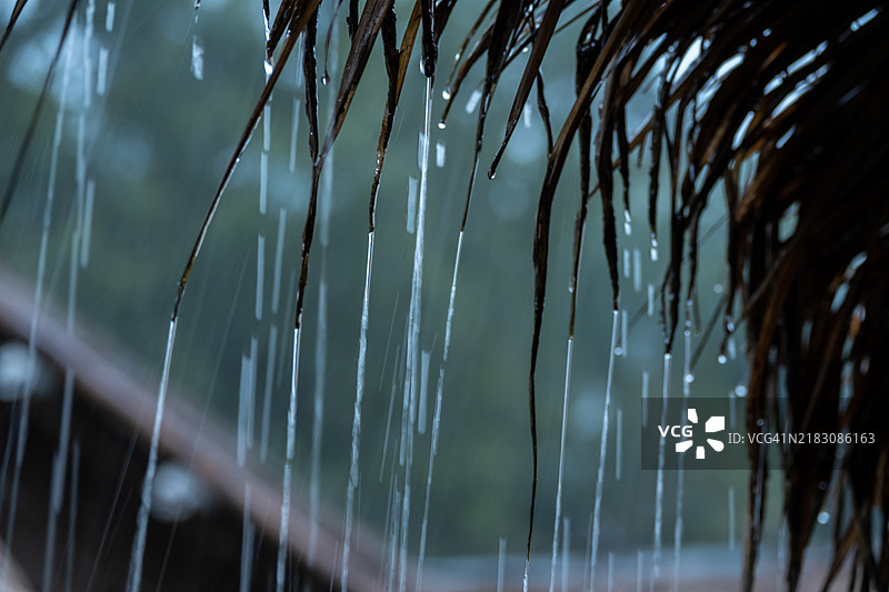 热带雨水在泰国的强降雨季节倾泻而下，沿着屋檐流淌。图片素材