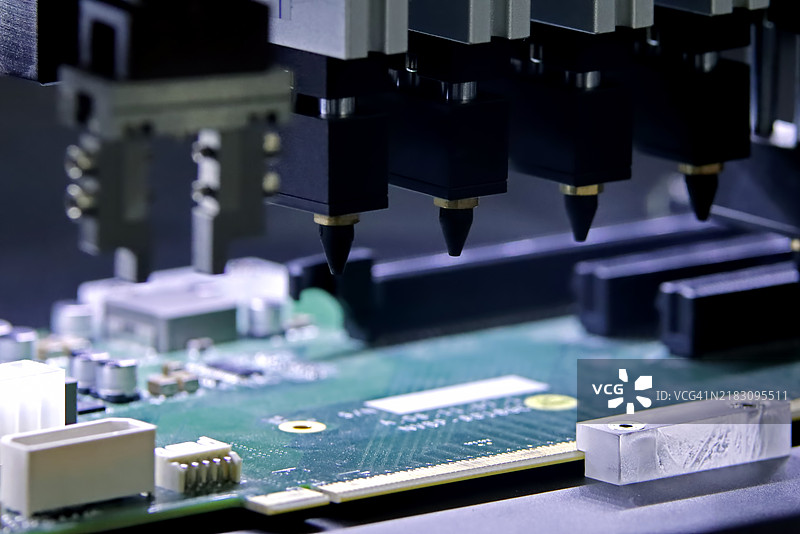 在工厂中用于焊接或焊接部件的印刷电路板组装机器的自动化机器人。图片素材