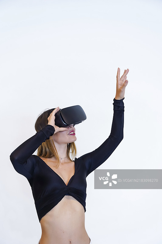 佩戴虚拟现实眼镜的女性，白色背景，未来概念，元宇宙，竖版照片图片素材