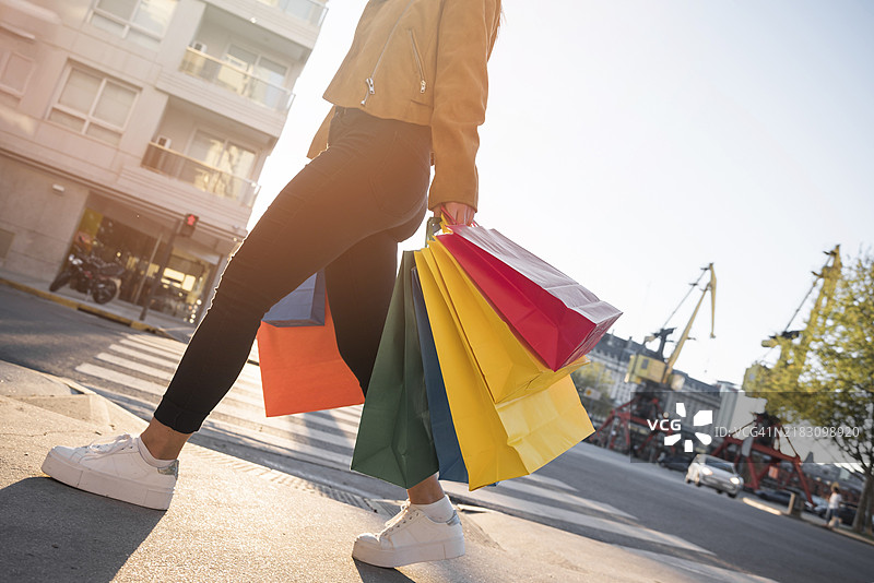 手提购物袋的年轻女士在街上图片素材