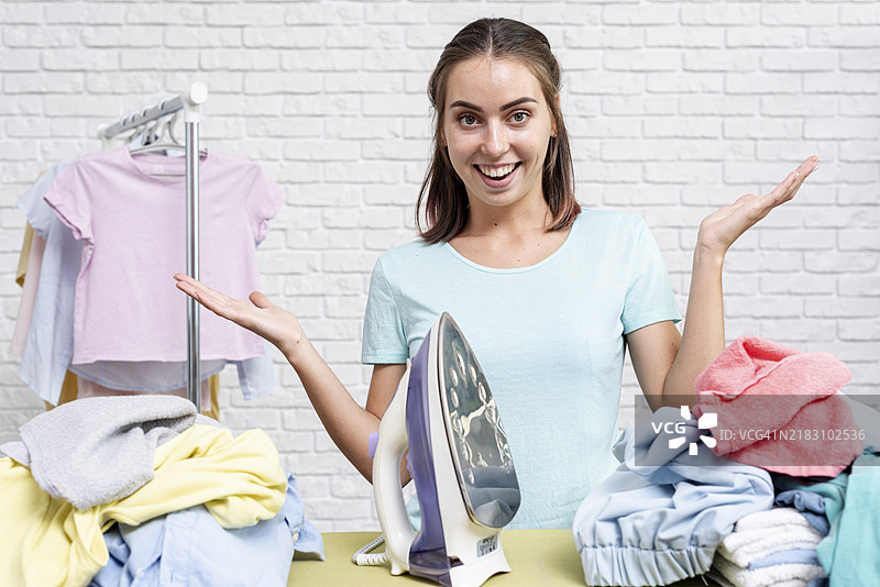 正面视角的女性准备熨烫衣物图片素材