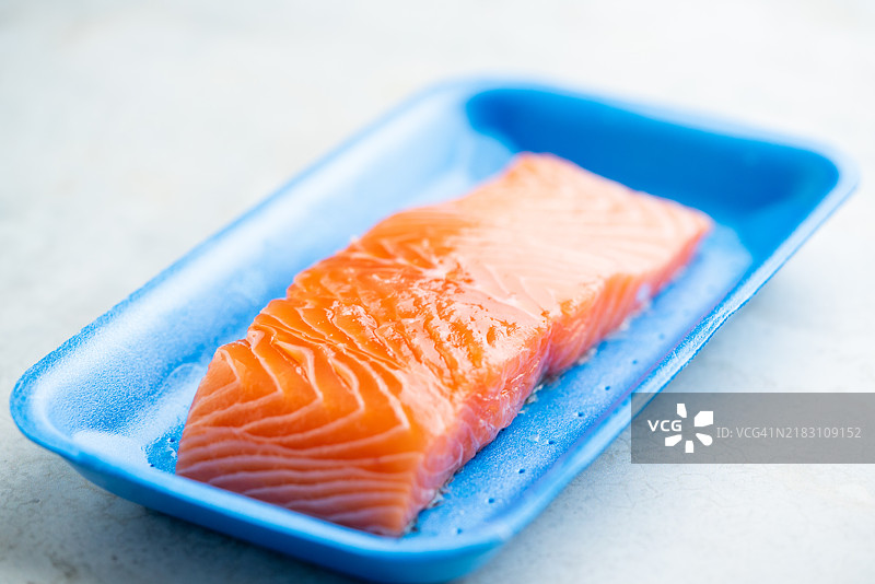 新鲜生三文鱼在塑料容器中，特写视图图片素材