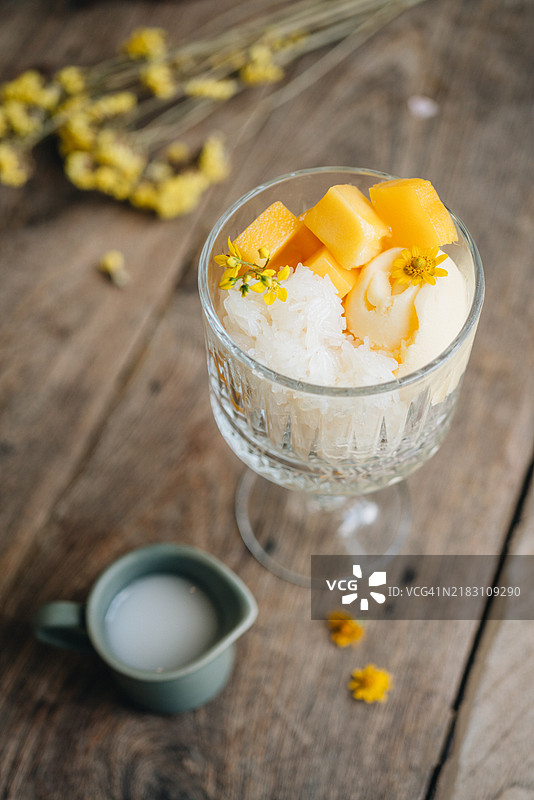 一个装有椰子冰淇淋、芒果糯米饭和椰子酱的冰淇淋碗图片素材