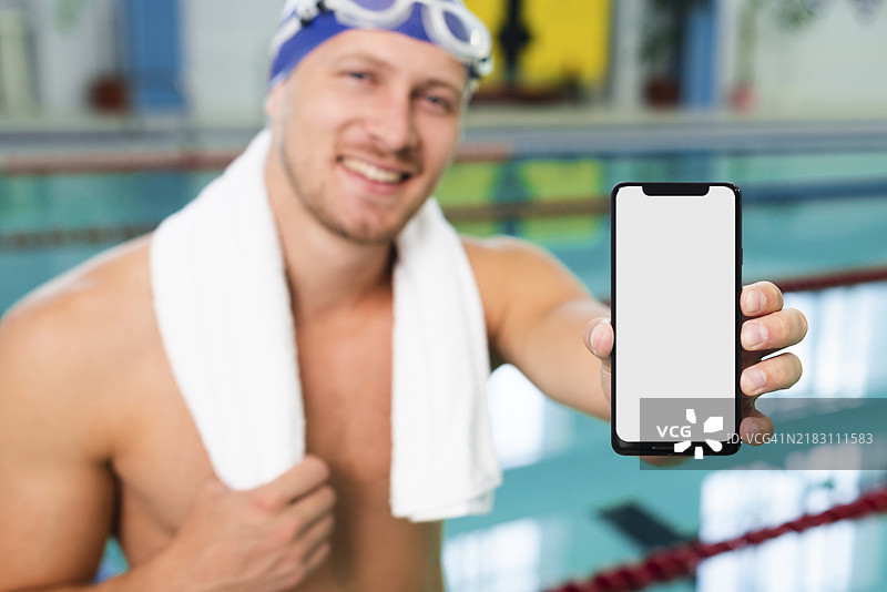 高角度年轻男子在泳池边拿着手机图片素材