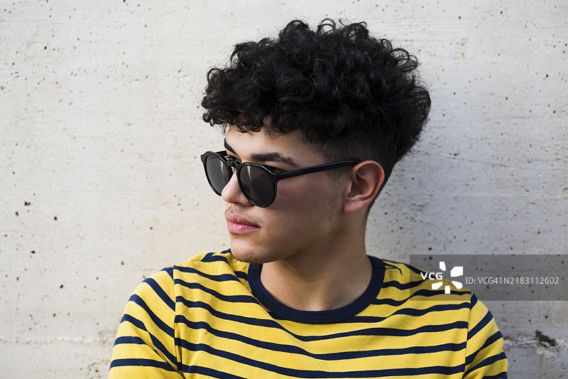 黑色卷发男士，戴着太阳镜，穿着条纹衬衫图片素材