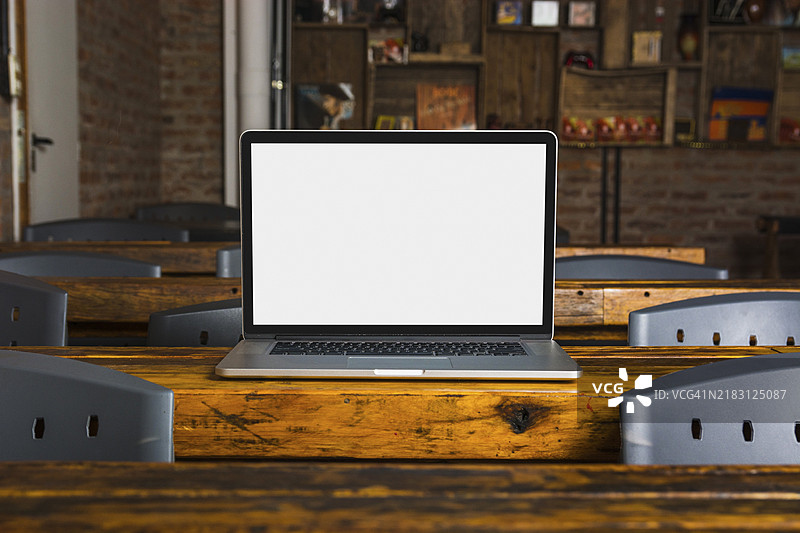 木桌咖啡馆里的白色显示屏笔记本电脑图片素材