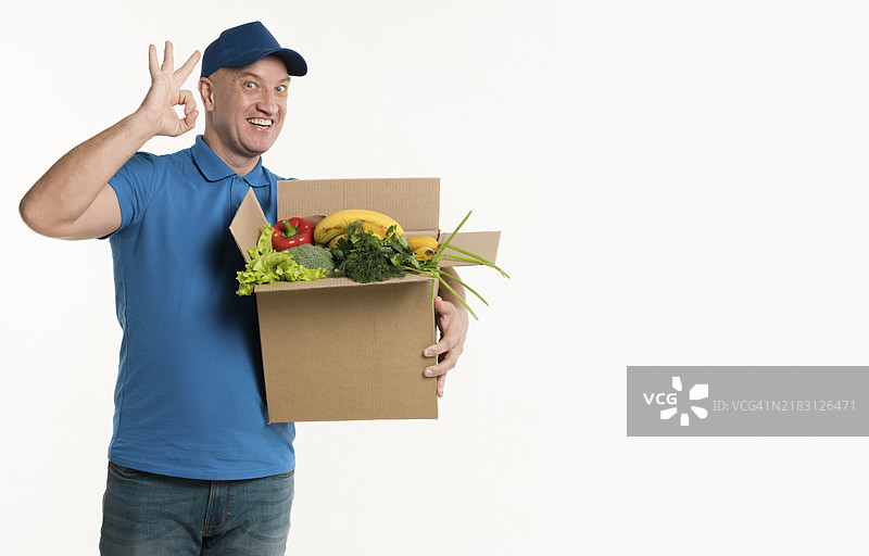 送货员手持杂货箱做出“好的”手势图片素材