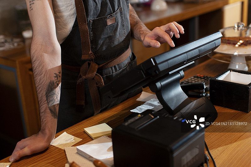 近距离拍摄的男子在操作收银机图片素材
