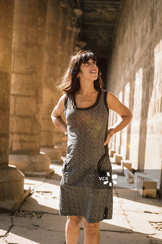 埃德夫神庙柱子旁年轻的棕发女性肖像，位于埃及阿斯旺市，尼罗河西岸，埃德夫市，希腊-罗马建筑，献给霍鲁斯。图片素材