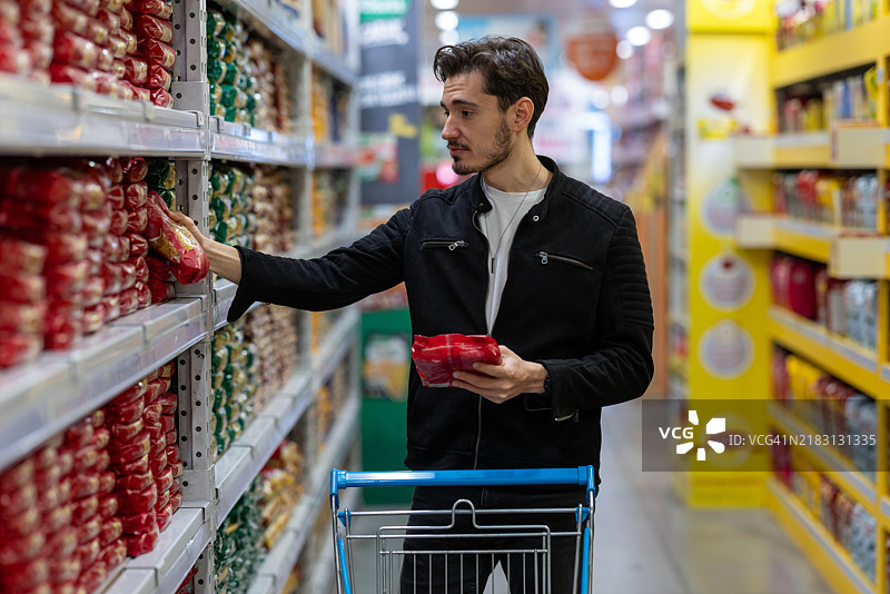 年轻的商人在超市食品部门购物。图片素材