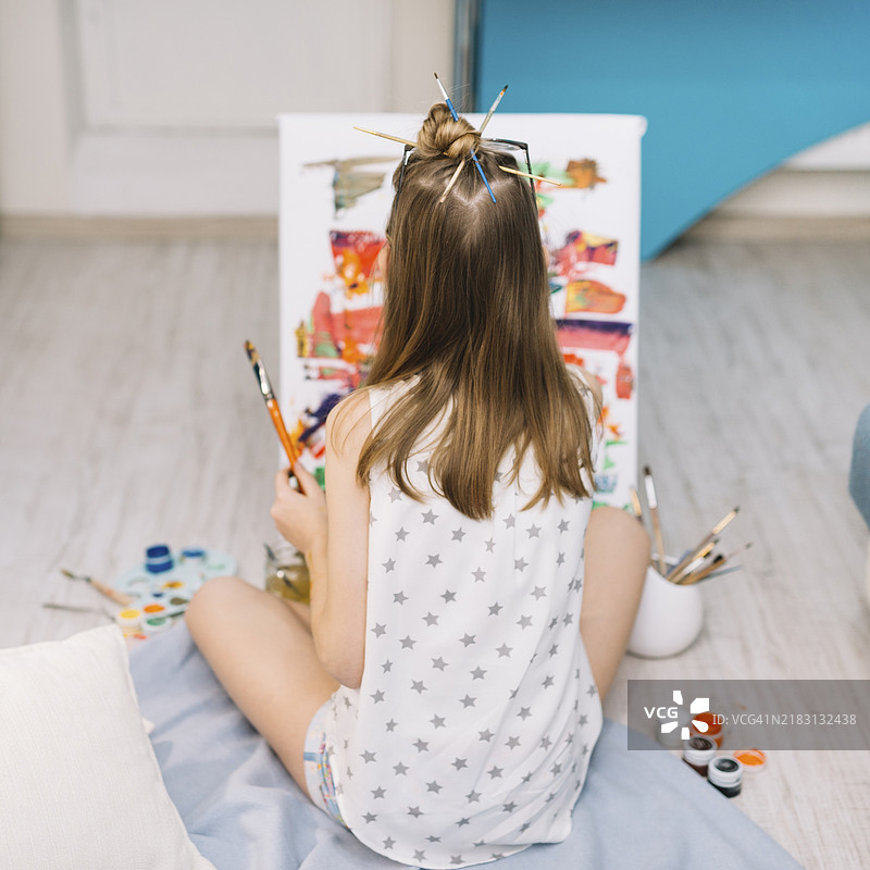 白人女孩坐在地板上用水粉画画图片素材