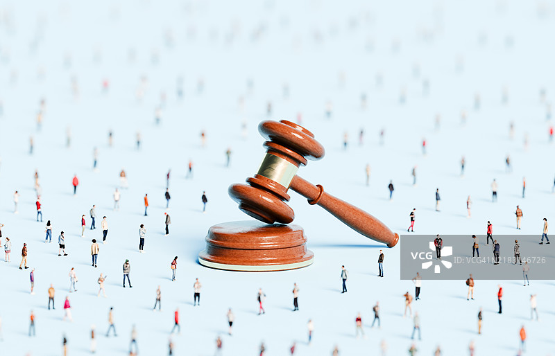 一大群人围绕着一个巨大的法槌图片素材