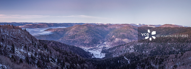 冬季黄昏时分，雪覆盖的沃日山脊全景，远眺圣莫里斯村和大球山，视角来自阿尔萨斯山顶，沃日山自然区域公园 - 洛林 - 法国。图片素材