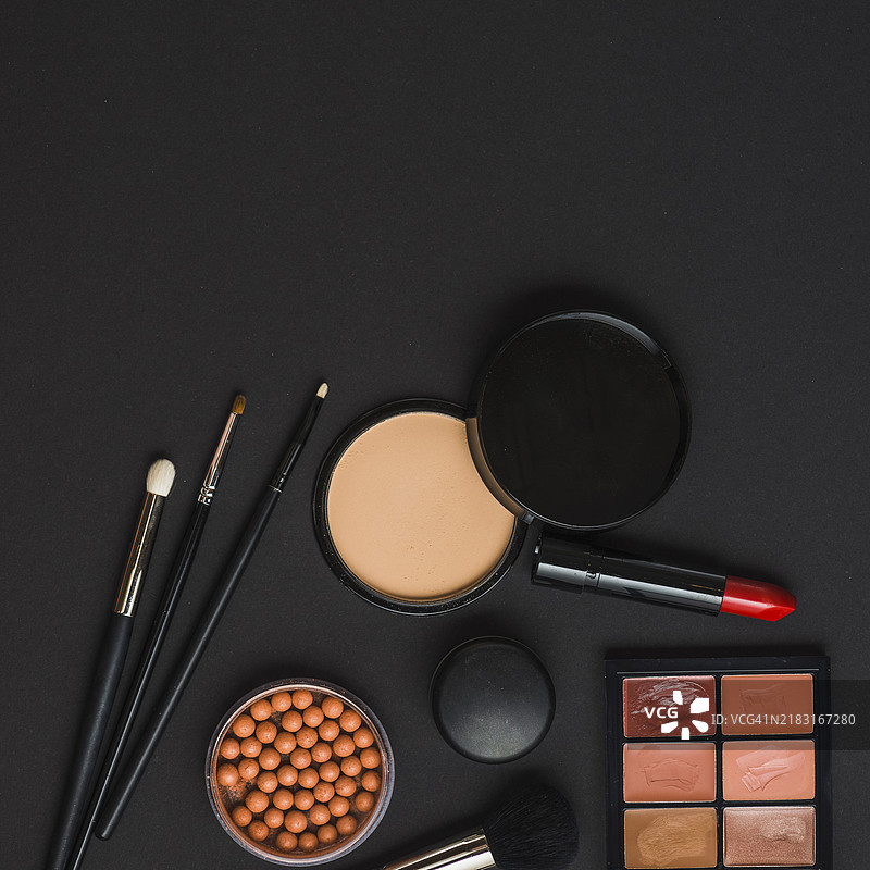 化妆产品与刷子的俯视图，黑色背景图片素材