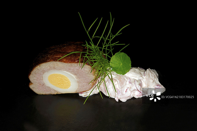 假兔肉，鸡蛋和萝卜沙拉填充的肉饼，黑色背景的美食摄影图片素材