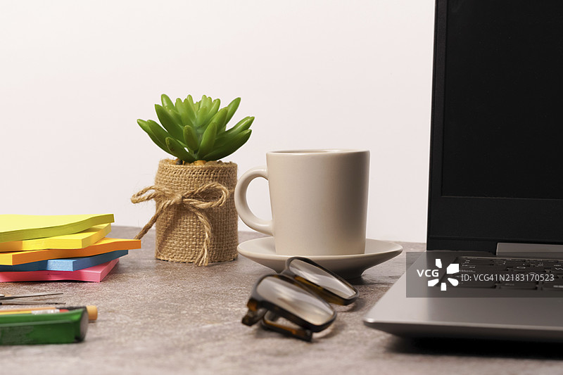 办公桌上放着笔记本电脑和其他工作工具，还有一杯咖啡。留有空白处以便输入文本。图片素材