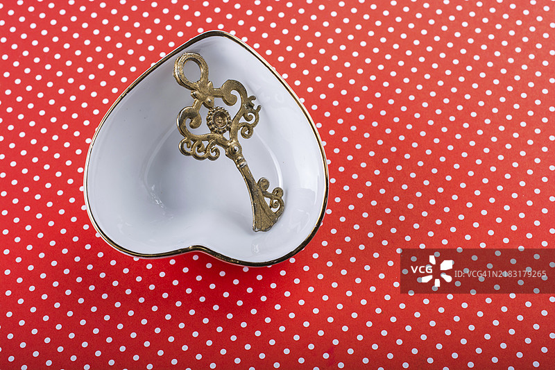 复古风格的装饰钥匙放在心形碗中图片素材