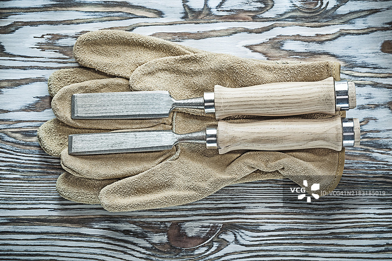 安全手套和扁凿放在木板上图片素材