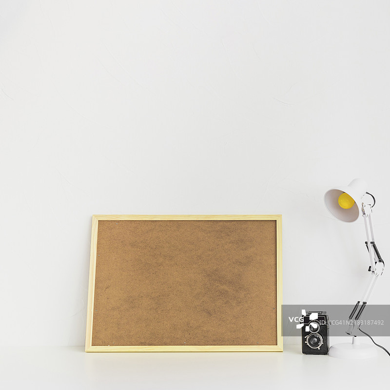 极简主义的工作空间，配有软木板和老式相机图片素材