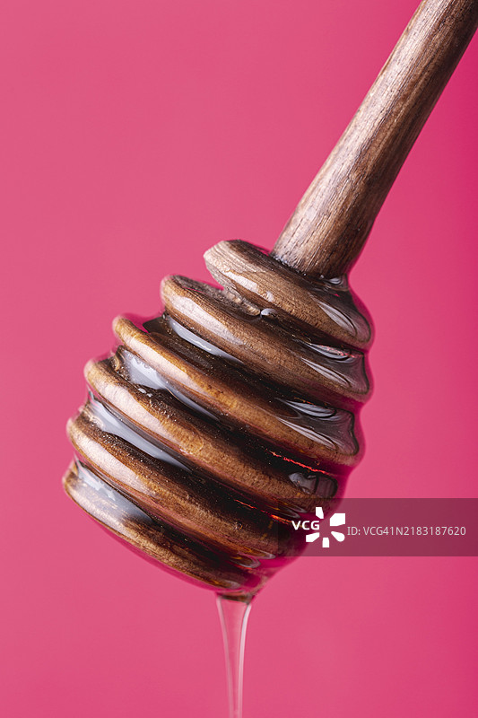 木勺上滴落的蜂蜜特写镜头图片素材