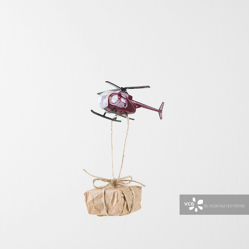小礼品盒悬挂在飞行的直升机上图片素材