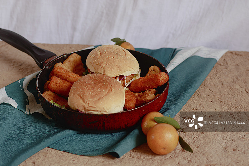 自制鸡肉汉堡、奶酪条和煎香肠在平底锅中，宁静秋晨的舒适早餐图片素材