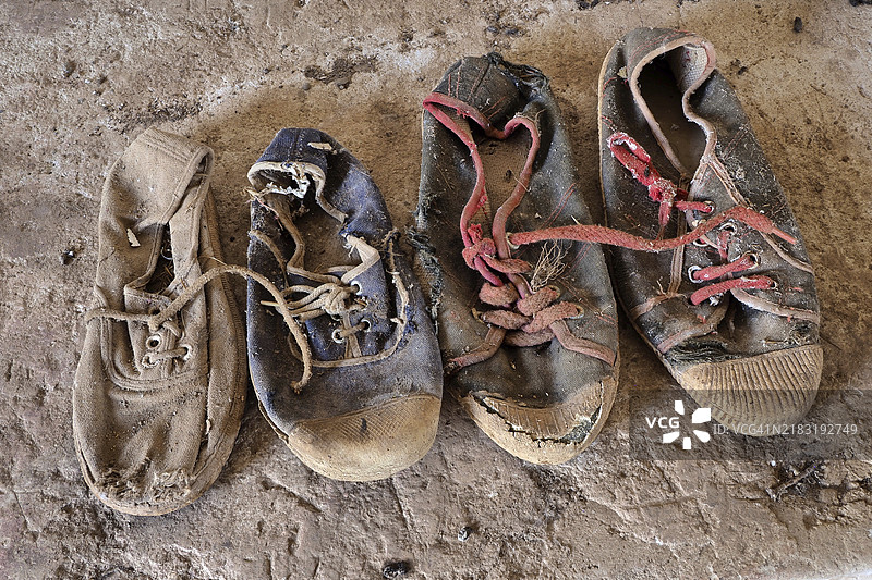 地板上的破旧休闲鞋，腐烂的鞋子，鞋子残骸，腐烂的运动鞋，磨损的鞋子，磨损的鞋子图片素材