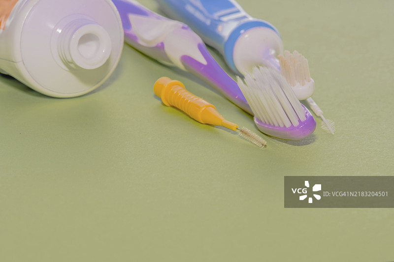 牙刷和牙线夹的特写，旁边是打开的牙膏管图片素材